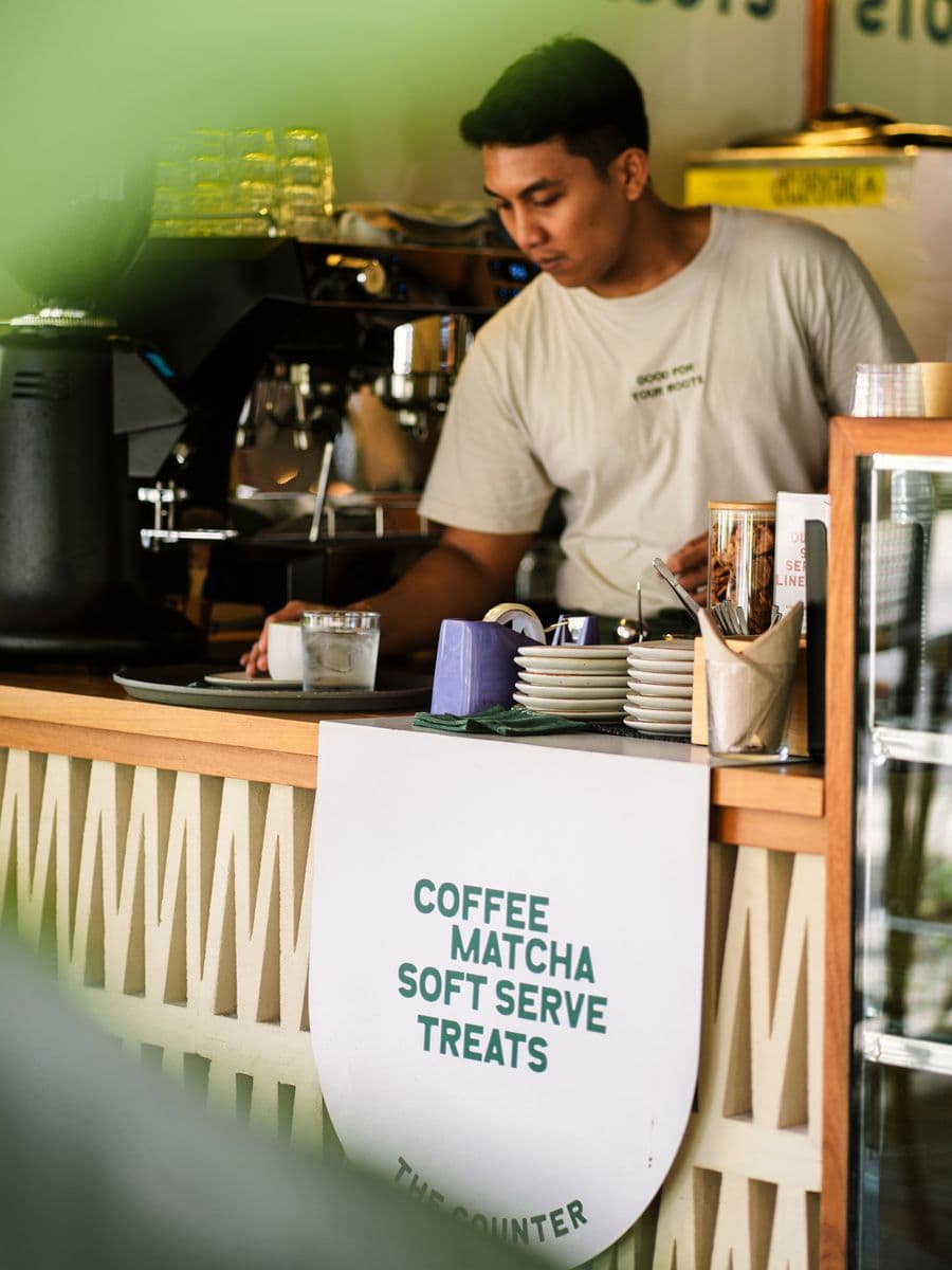 Barista pulling a shot behind the counter of a Pererenan café
