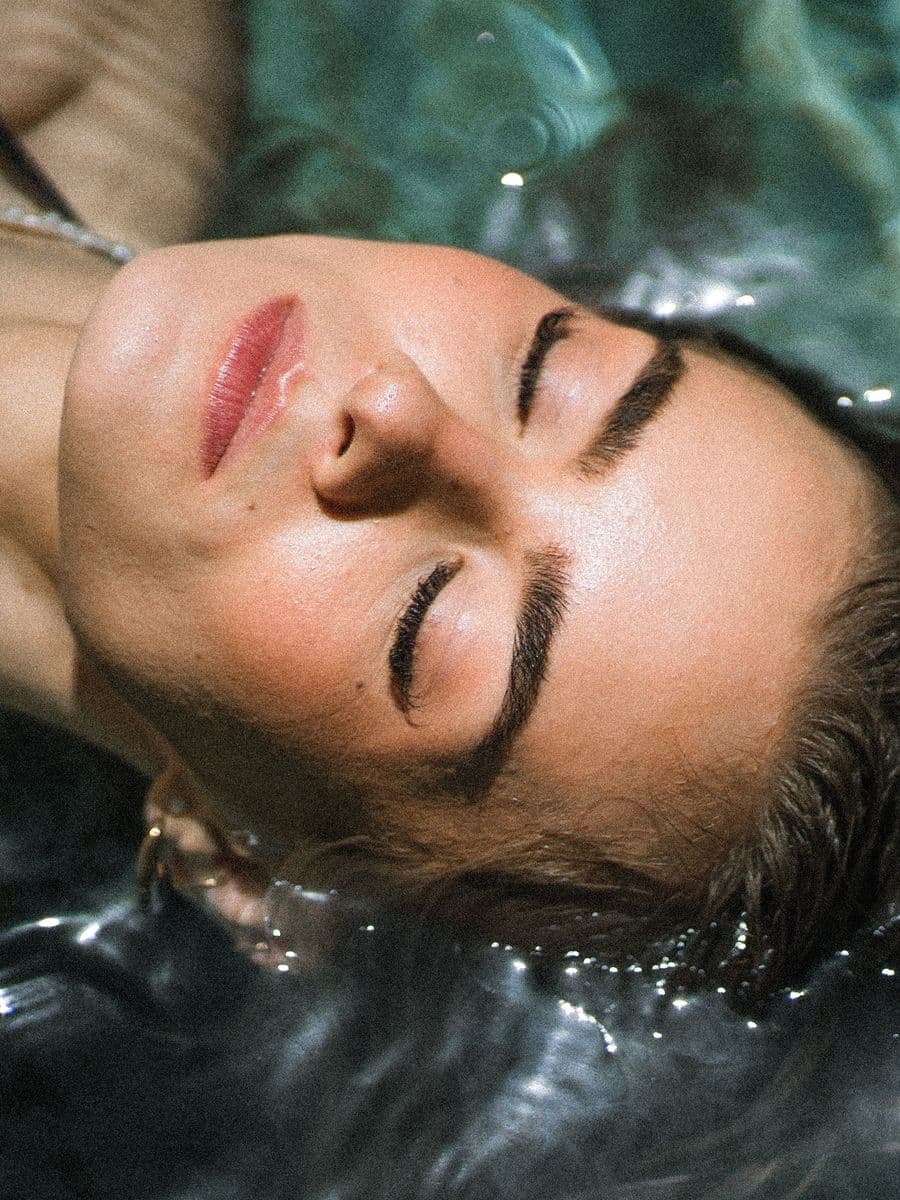 Guest floating in the pool, eyes closed — the slow afternoon before a spa treatment