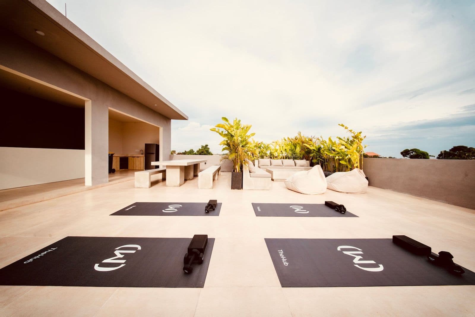 The rooftop terrace at TheHub with dining table, sofa lounge and yoga space